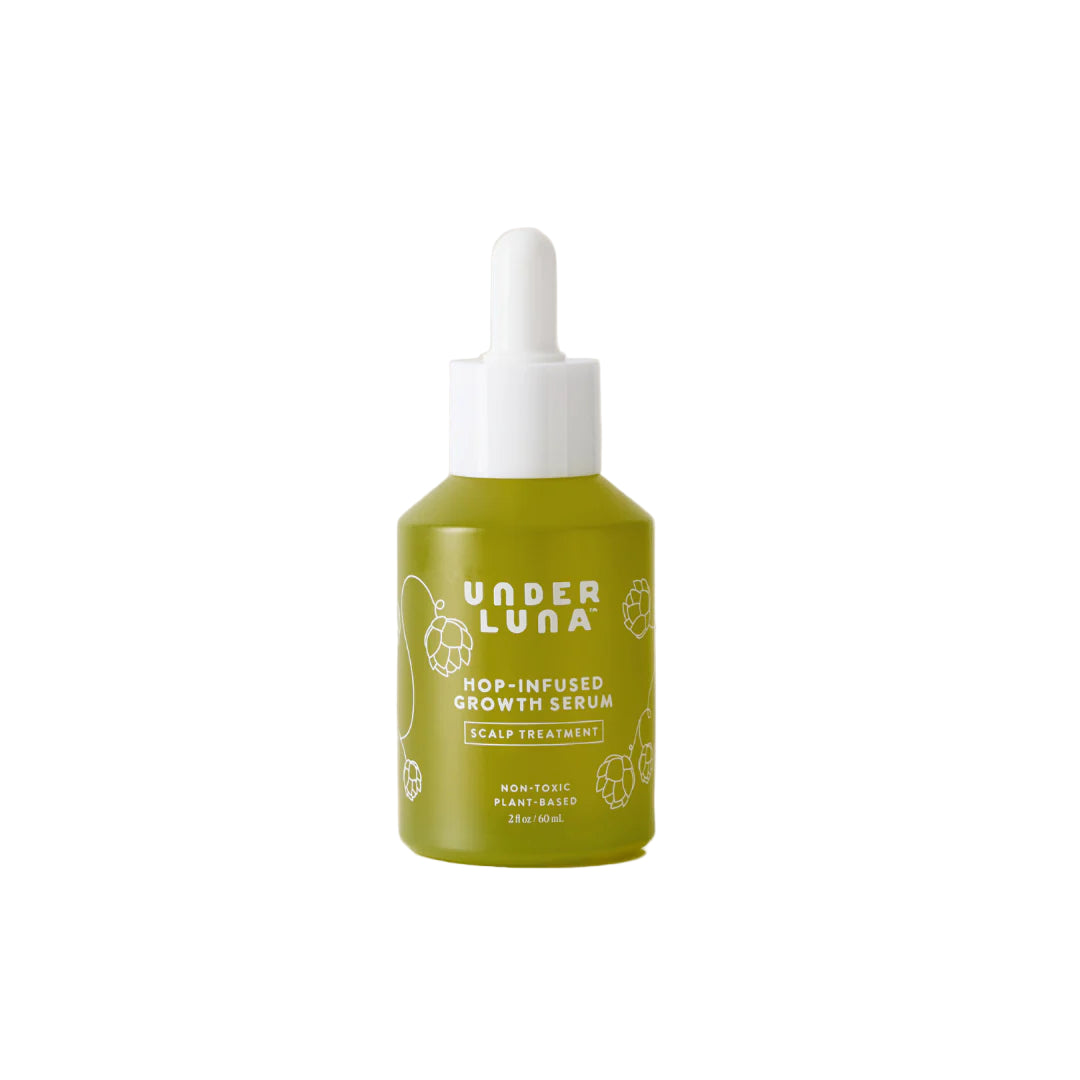 Green bottle of Under Luna hop-infused growth serum on a beige background
