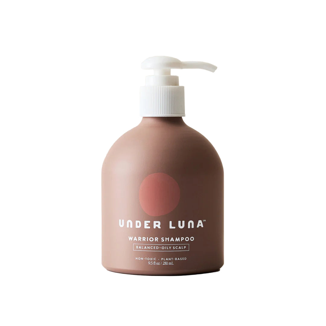 Brown aluminum shampoo bottle with pump labeled 'Under Luna' on a beige background